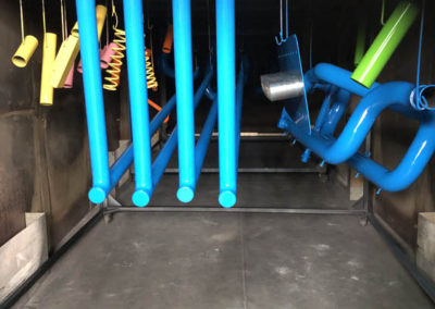 Steel frames drying after being coated in three different colours.