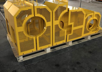 Excavator parts stacked on a pallet after being powder coated yellow