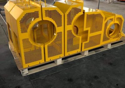 Varying sized road machinery parts after being powder coated safety yellow